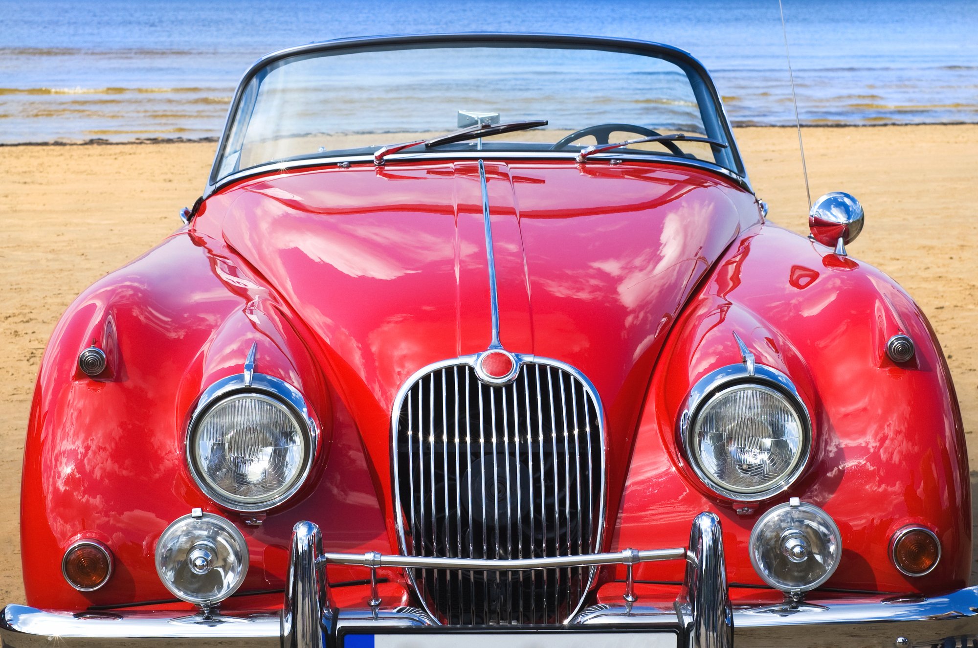 Old classic red car at the beach